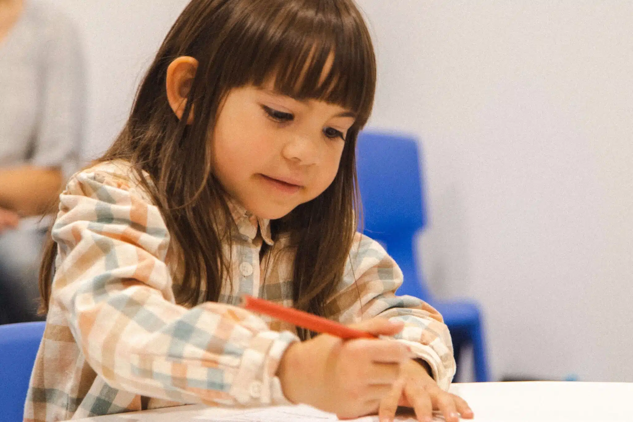 A preschooler writing with confidence - Early Development Gives Your Child a Head Start