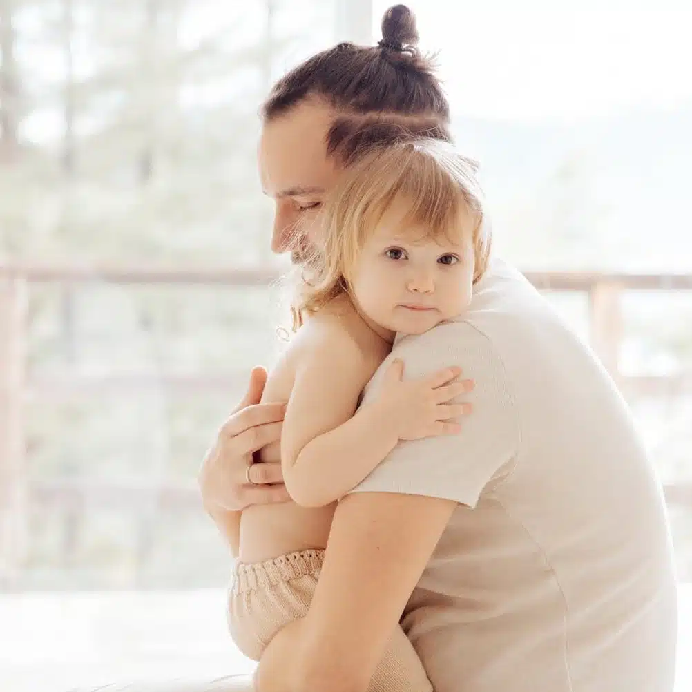 Building the Brain with love as you raise your kids, showing a father hugging his toddler lovingly