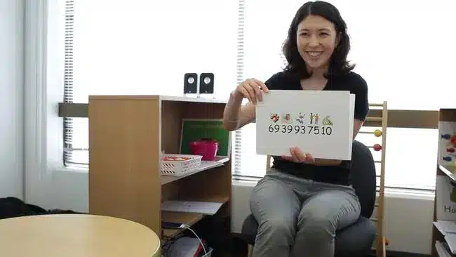 Friendly Shichida teacher showing flashcards to a class