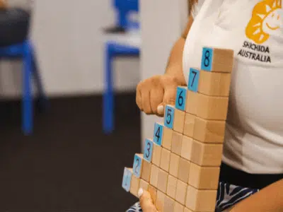 basic concepts in early learning, a teacher using blocks to teach numeracy