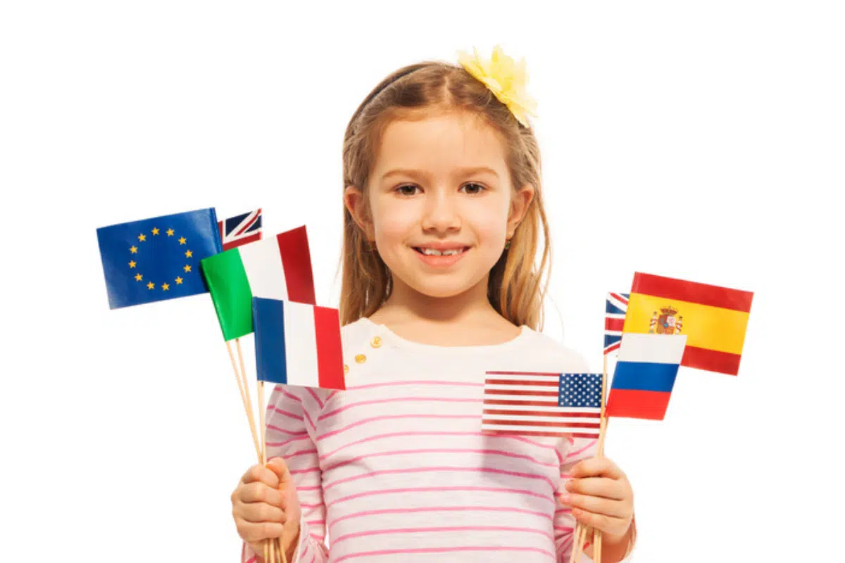 Benefits of Raising Multilingual Kids: A young girl with several national flags of different countries