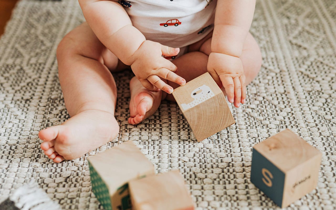 Baby brain development showing a baby playing with wooden blocks