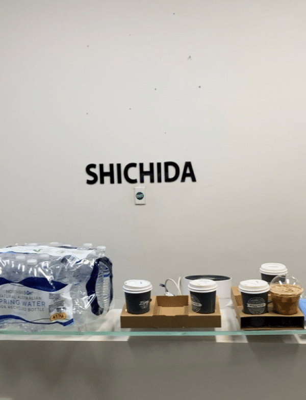A glass shelf with coffee cups and water bottles