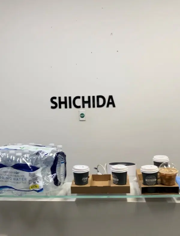 A glass shelf with coffee cups and water bottles