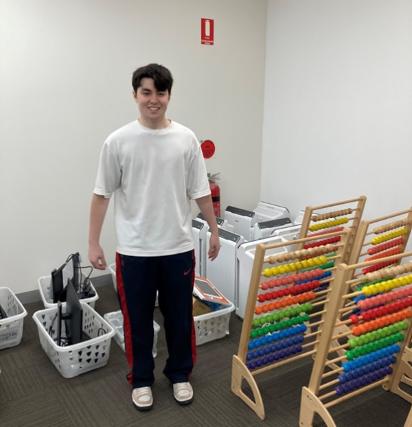A Shichida teacher standing next to class equipment stacked together on moving day