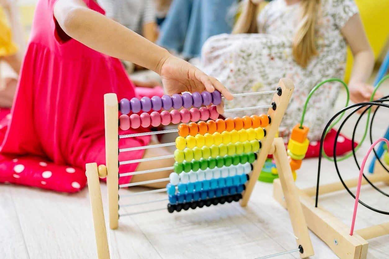 Proven Maths Teaching Methods That Lead to Exceptional Results, here kids play with an abacus