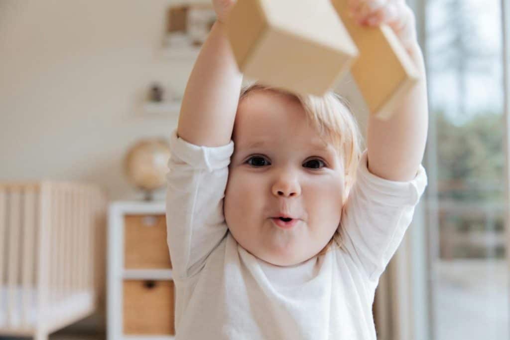 Understanding Developmental Milestones: a baby lifting a toy