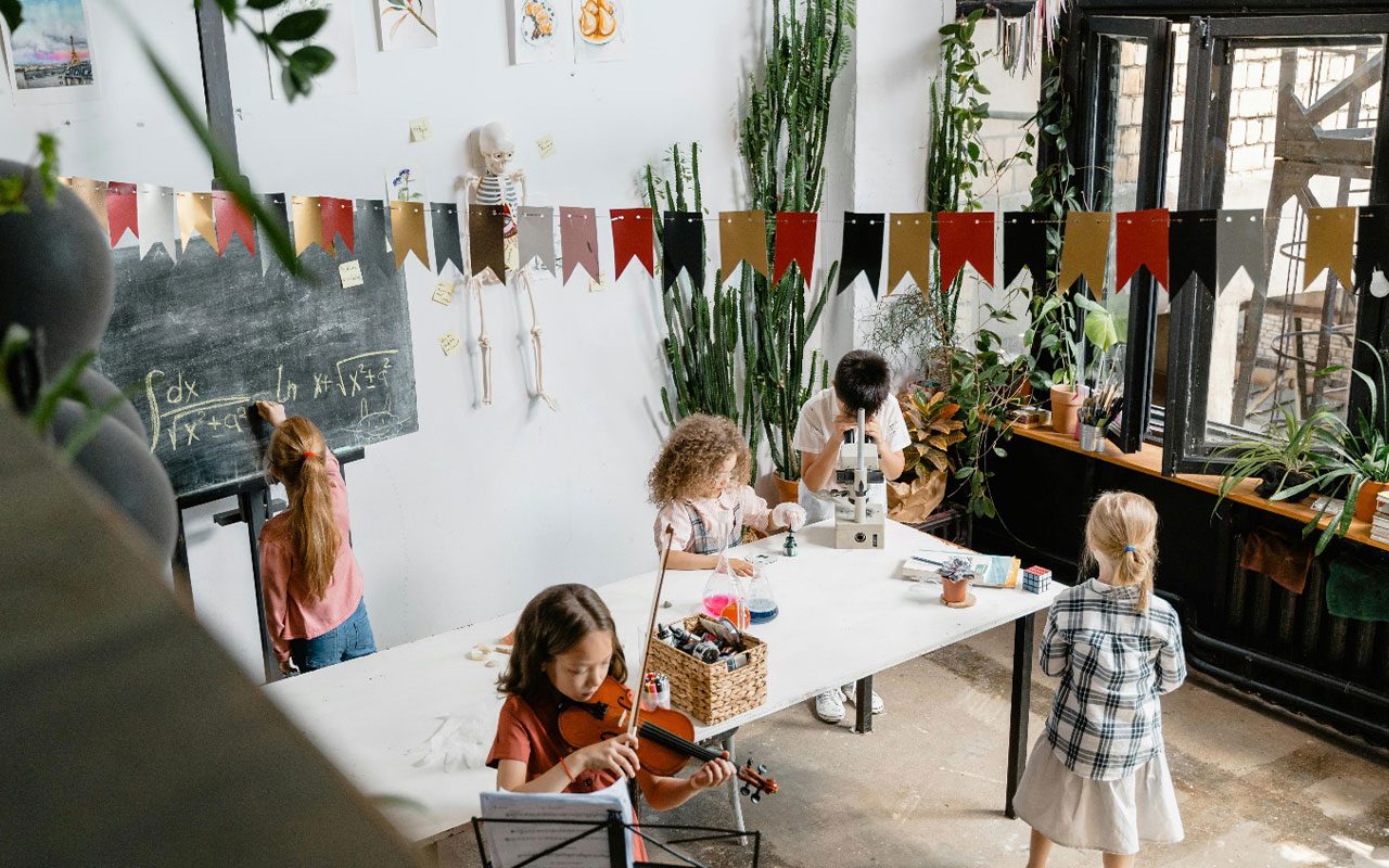 An enriching environment showing young boys and girls doing interesting activities like math, science and playing violin