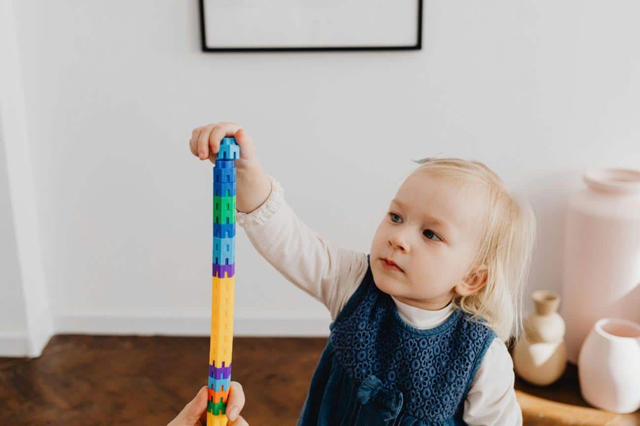Toddler Playing with Stacking Toys practicing Fine Motor Skills Activities