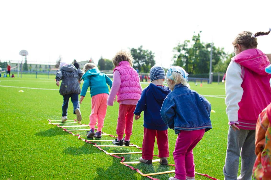 Kids playing a game on grass, developing skills through gross motor skill activities