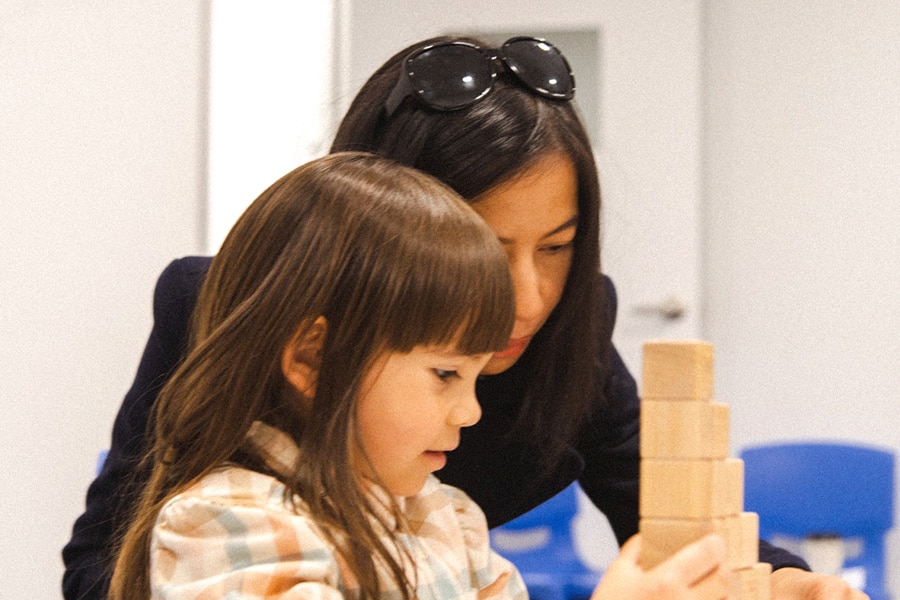 Boost child's confidence through playing games together. Here a mum and her preschooler play a block building game in a Shichida class together.