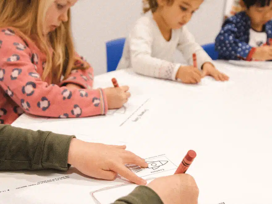 Preschoolers refining their fine motor control in a Shichida class. Here they are learning to draw a rocket using basic shapes - guided by a catchy song.