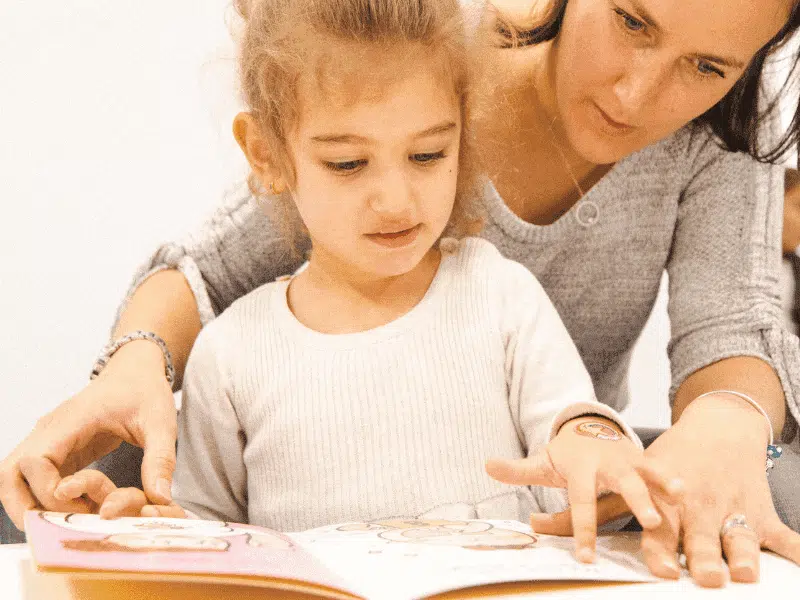 Mother teaching daughter with a Book during a Shichida class