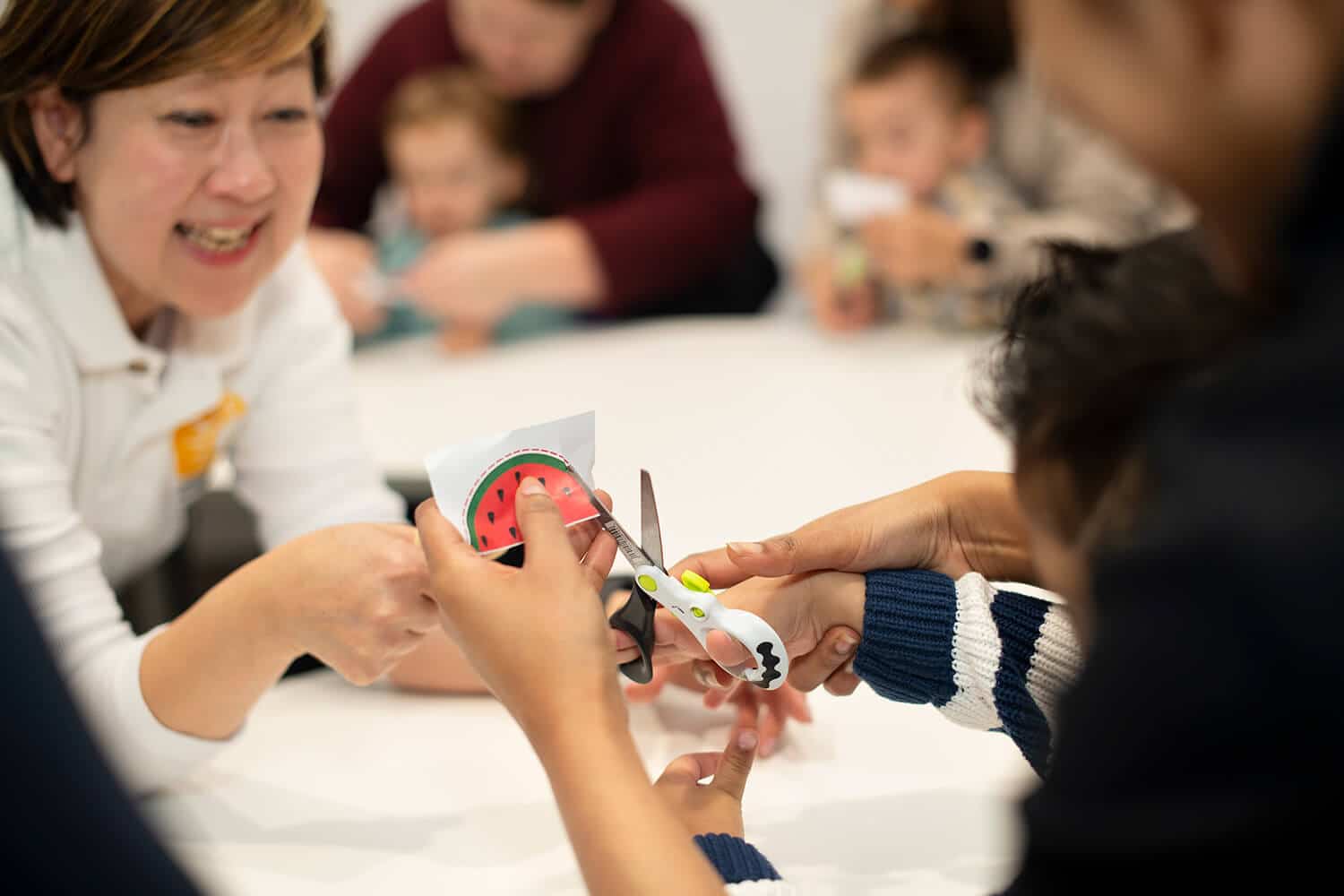 Toddlers practise cutting with safety scissors