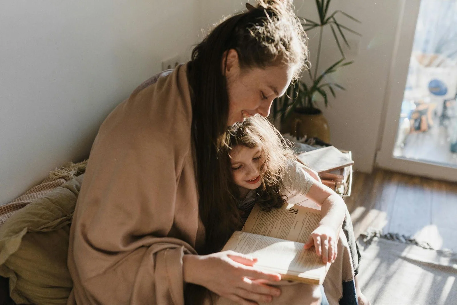mother and daughter reading a book - healthy screen time limits