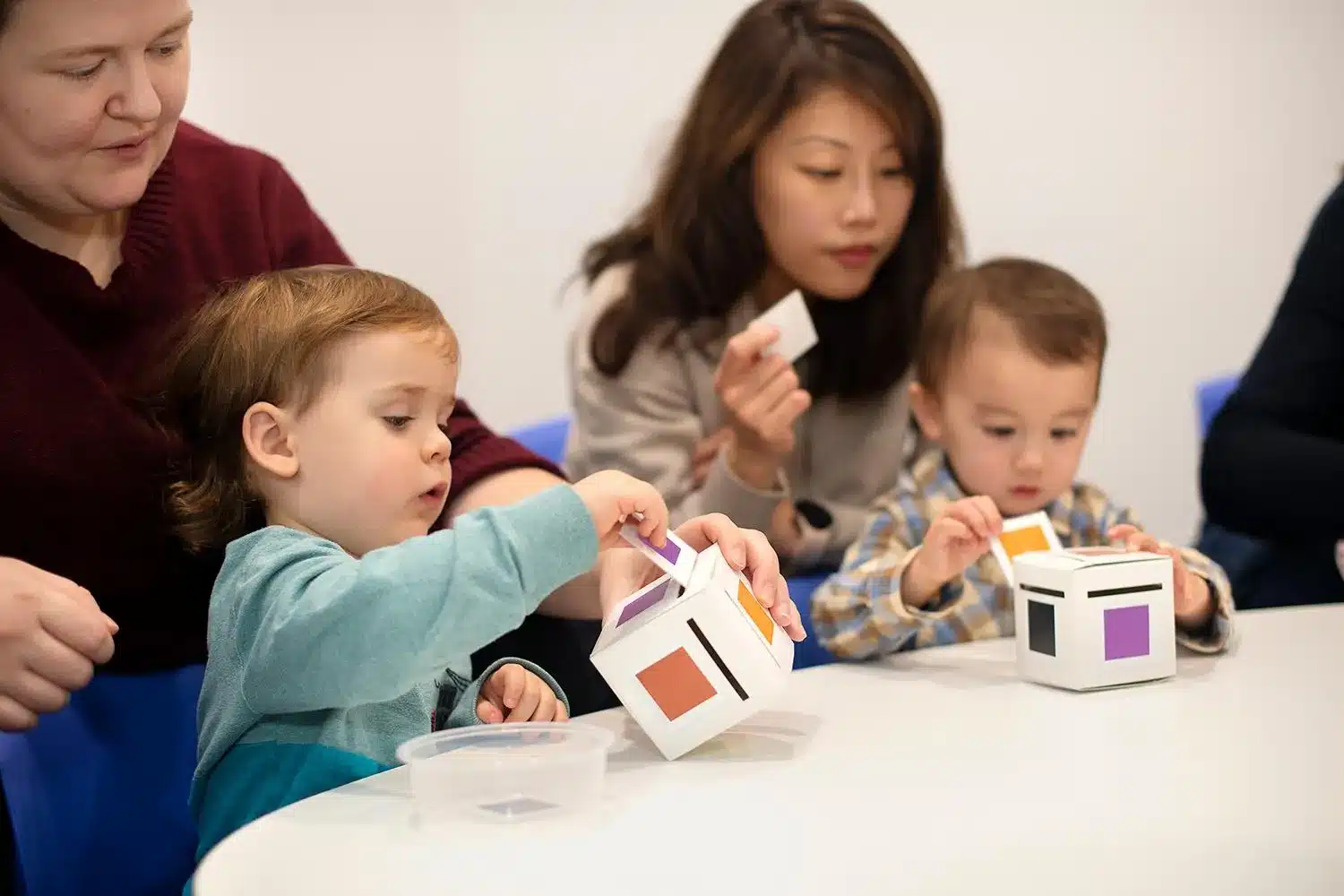 Image by Shichida Australia: As toddlers post each colour card into the matching box, they practise finger control, concentration, and colour learning.