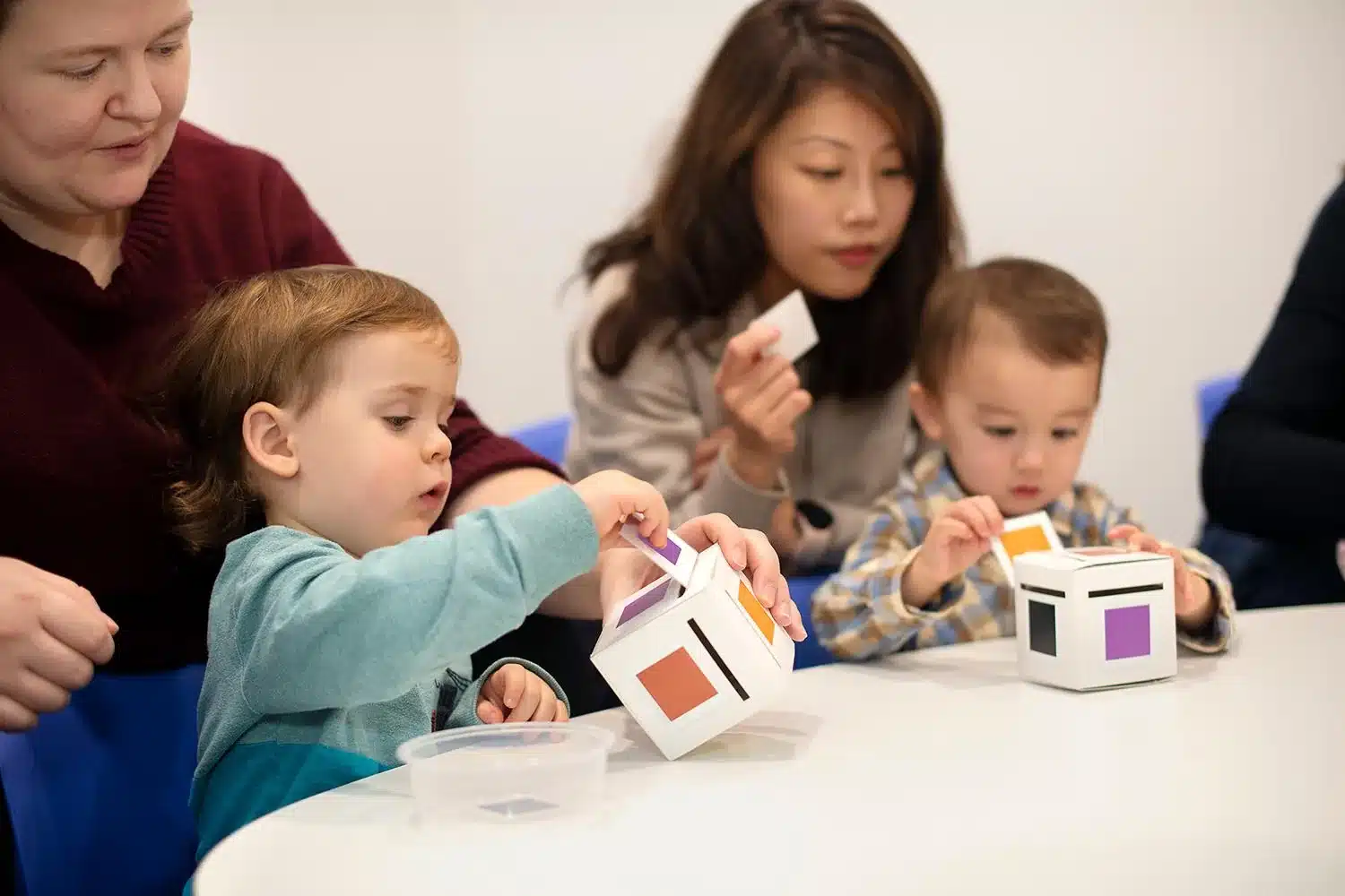 Toddlers matching coloured cards to a cube during a visual discrimination activity